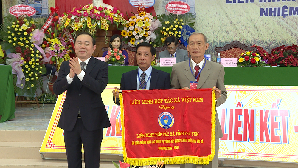 Chủ tịch Liên minh HTX Việt Nam Nguyễn Ngọc Bảo trao Cờ thi đua hoàn thành xuất sắc nhiệm vụ trong xây dựng và phát triển HTX giai đoạn 2012-2017 cho LMHTX tỉnh Phú Yên.